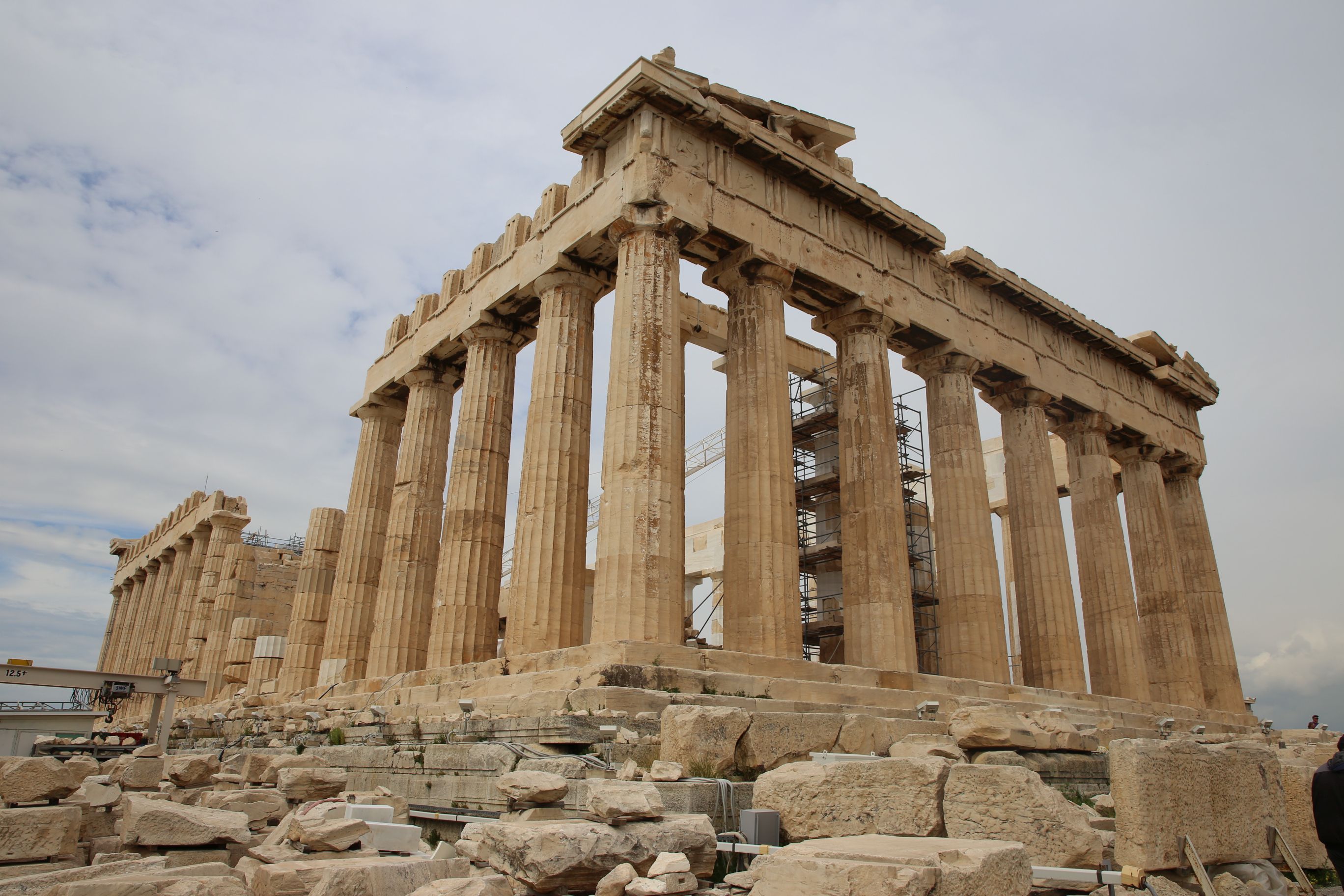 Das Parthenon in Athen. Ein teils wiederaufgebauter griechischer Tempel vor leicht bewölktem Himmel.